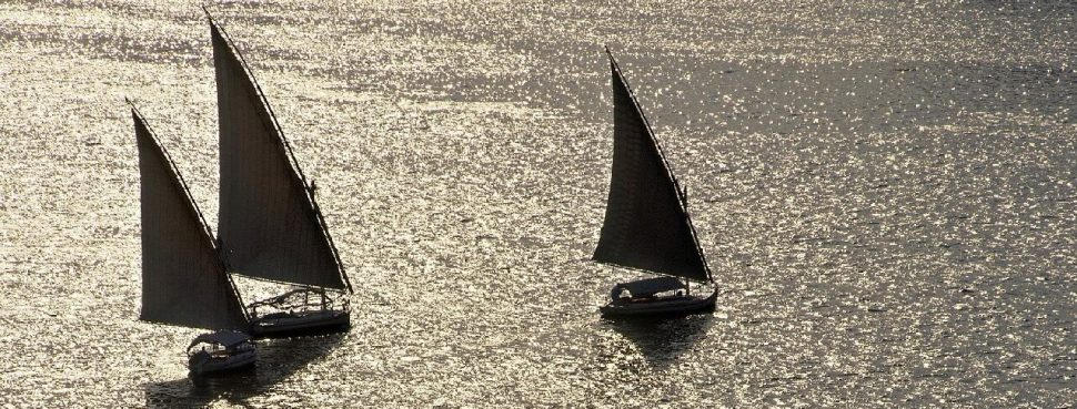 Three sailboats on water
