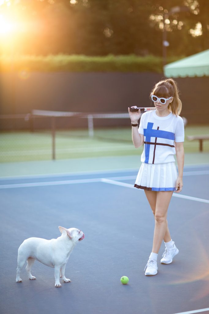 Woman with dog on tennis court