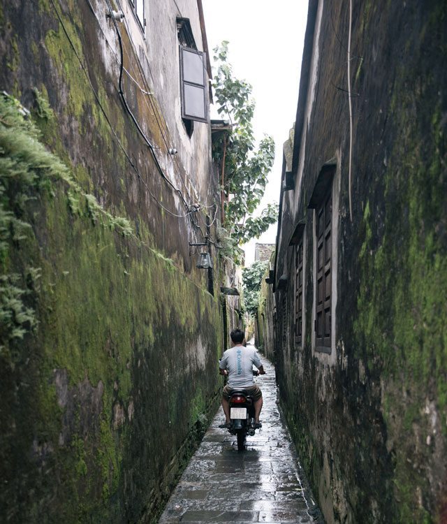 Man biking in alley in Hoi An