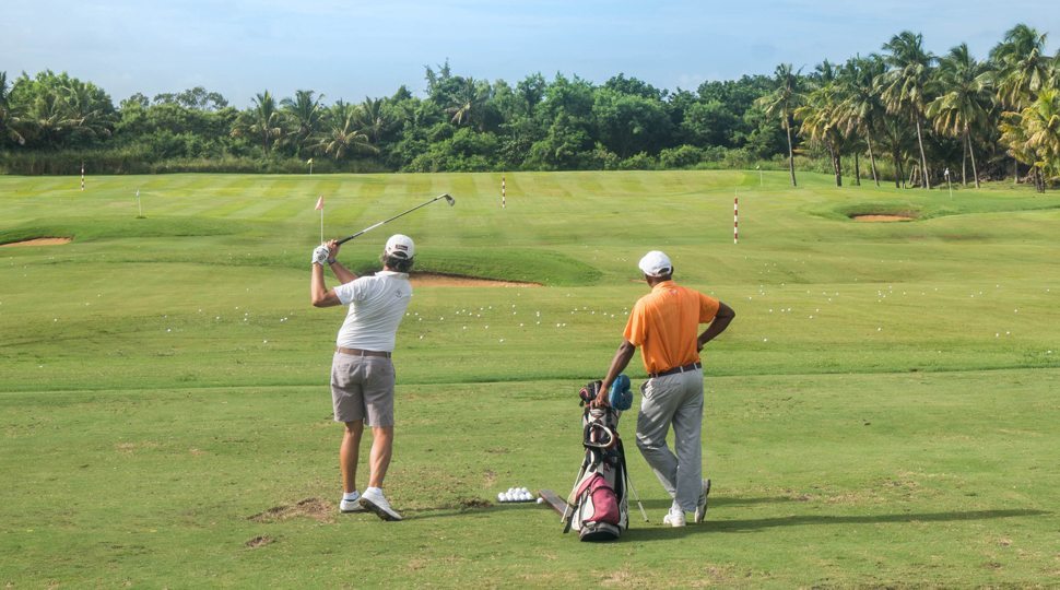Men play golf at the Four Seasons Mauritius