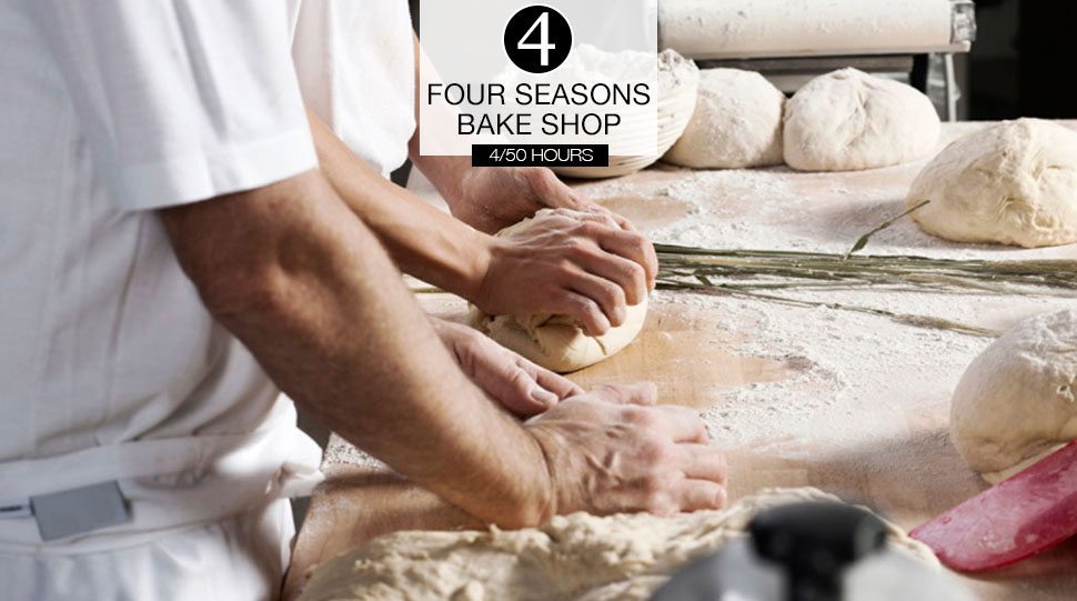 Chefs prepare dough in a kitchen.