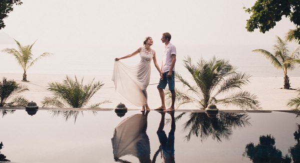Couple standing by edge of infinity pool