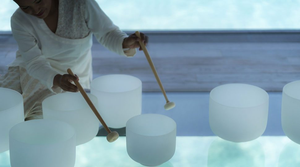 A spa expert at the Four Seasons Maldives provides sound therapy.