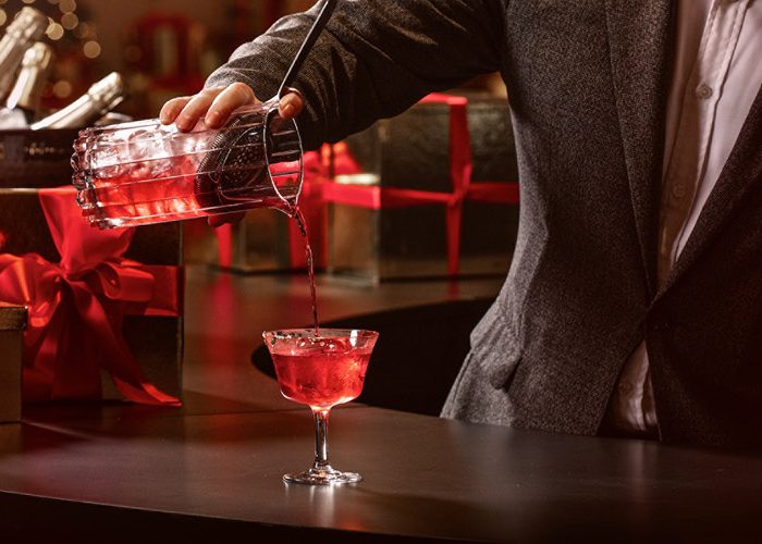 Mixologists pours a holiday cocktail