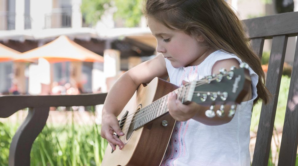 A young girl learns guitar in Austin