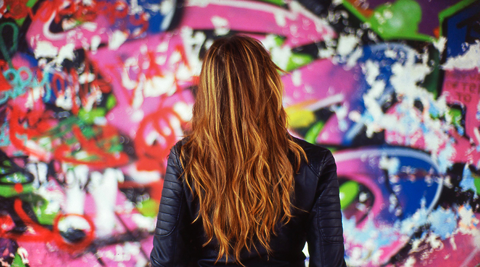 France, Rear View Of Young Woman In Front Of Colorful Mural