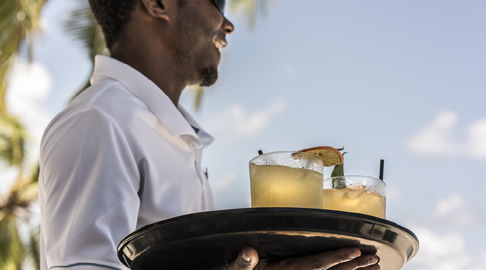 Waiter carries a tray of cocktails