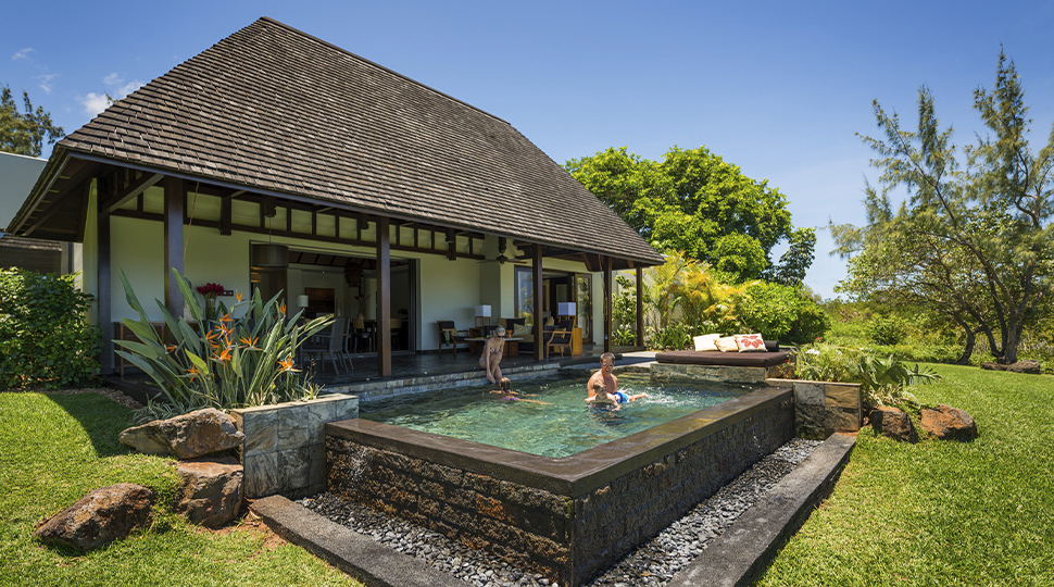 A family swims in a private pool at the Mautitius at Anahita Garden Residence Villa