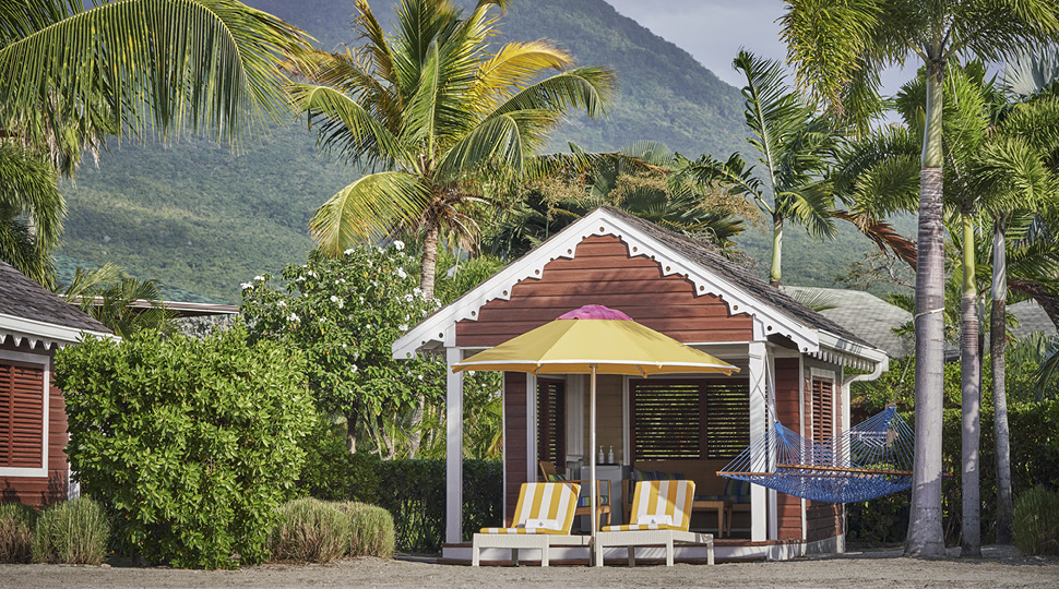 Empty beach cabana with yellow chairs and yellow umbrella