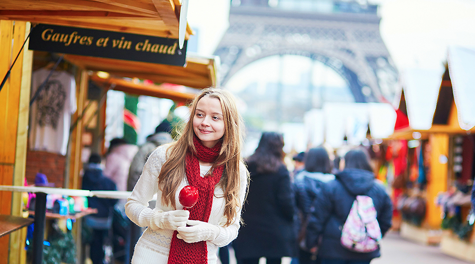 Happy,young,girl,with,caramel,apple,on,a,parisian,christmas