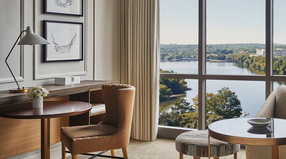 Hotel room sitting area featuring floor-to-ceiling windows looking out onto Lady Bird Lake in Austin