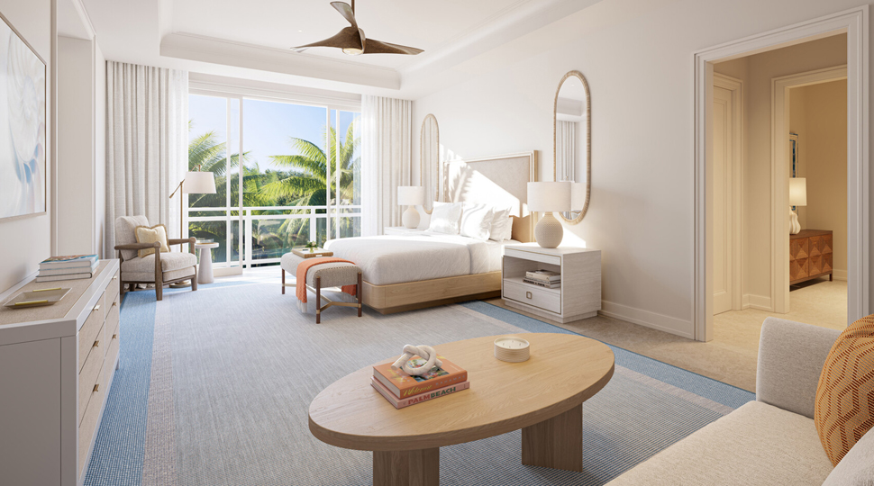 Large bedroom with tall ceilings, light-blue rug, white walls, a seating area, bed and a wall of floor-to-ceiling windows