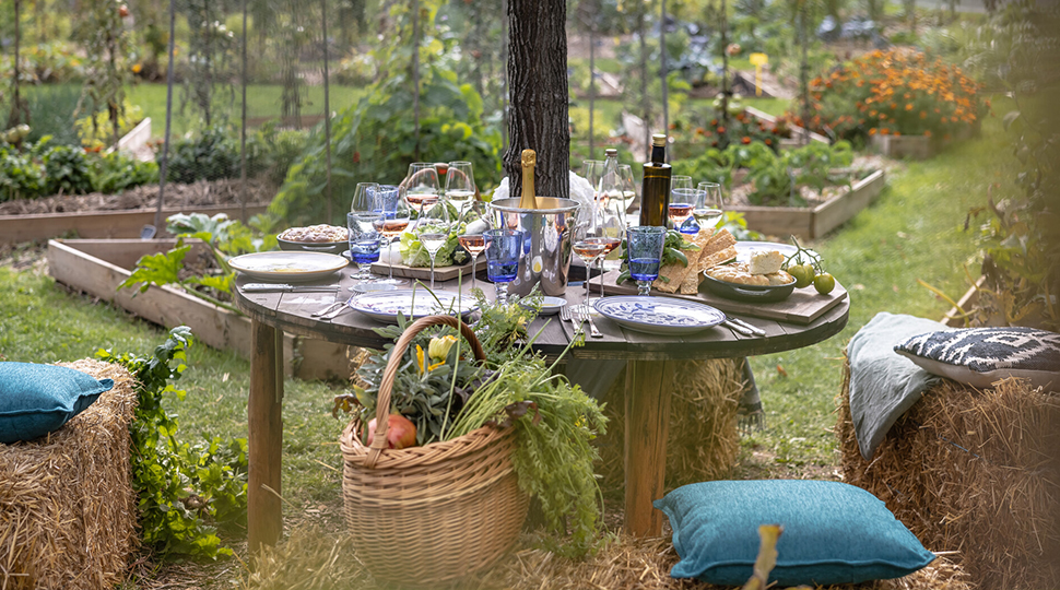 A rustic table set in the middle of a garden for lunch