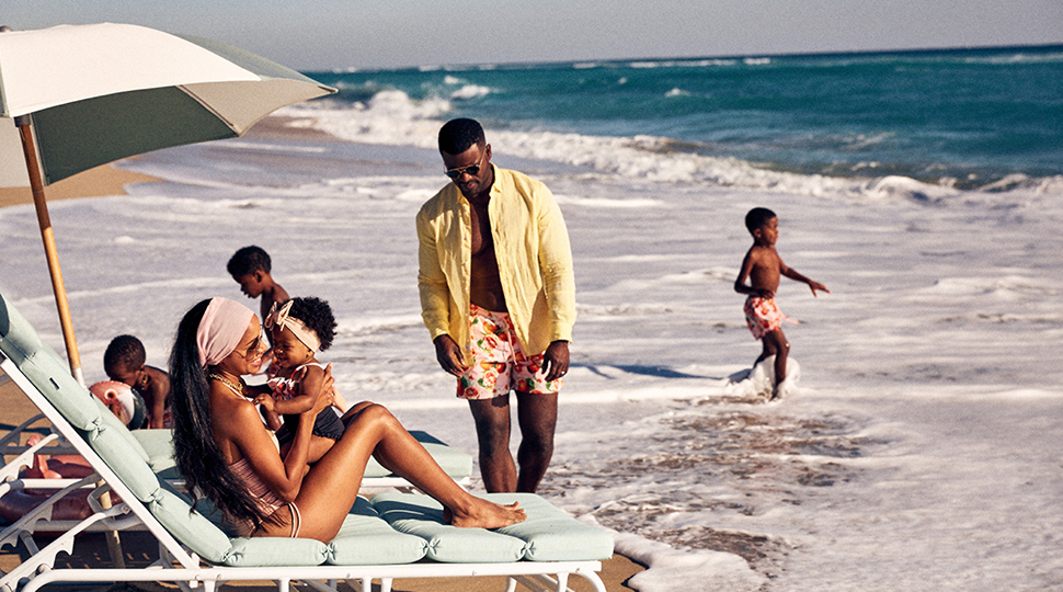 Family of six frolics by the water on a beach