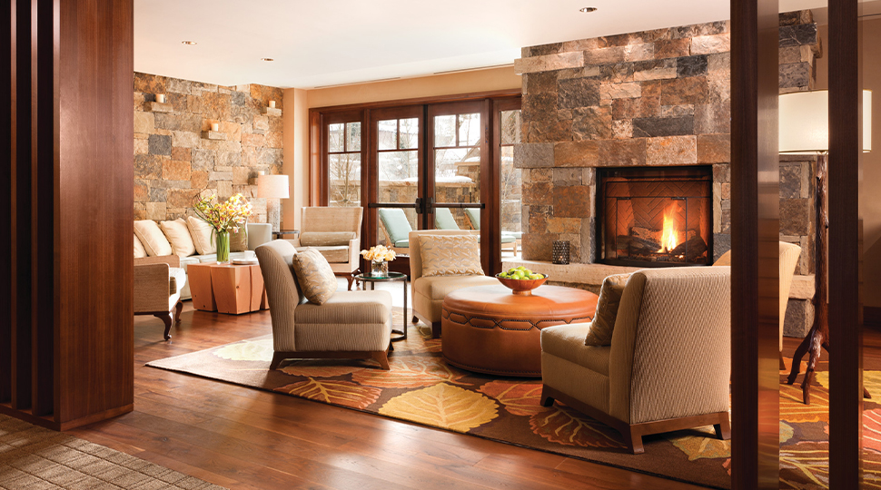 Spa lounge with various seating options and a stone fireplace in the middle