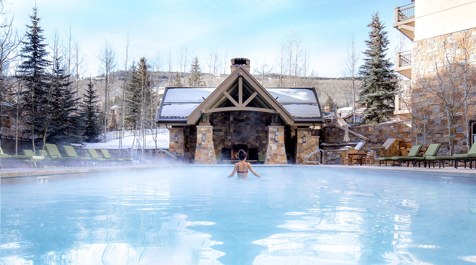 Person walks through a heated outdoor pool with seam rising from it