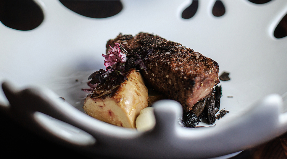 Close up of a steak plated in a white bowl