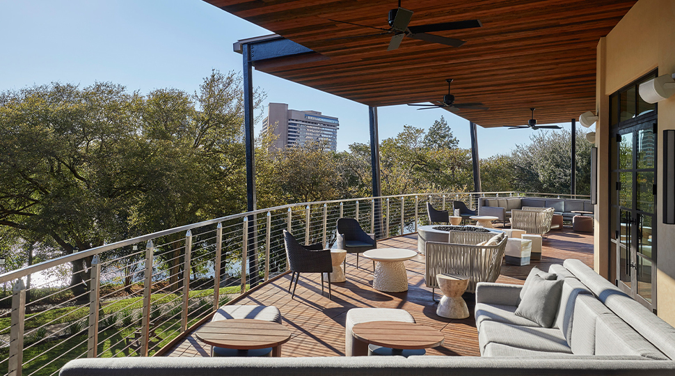 Covered outdoor deck overlooking a shady green lawn