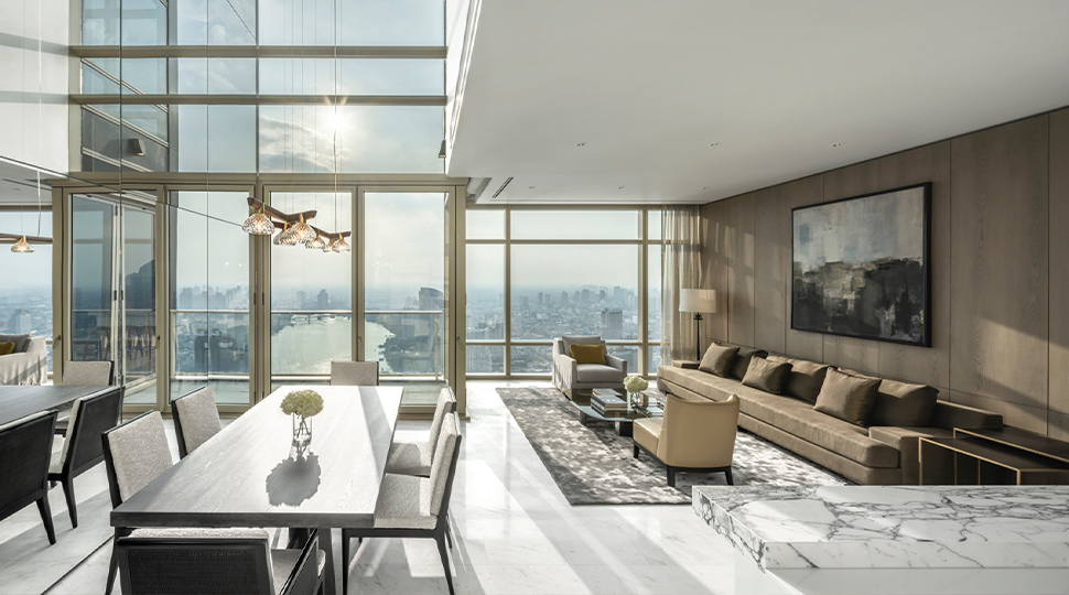 Two-storey living room with a wall of windows overlooking the city skyline