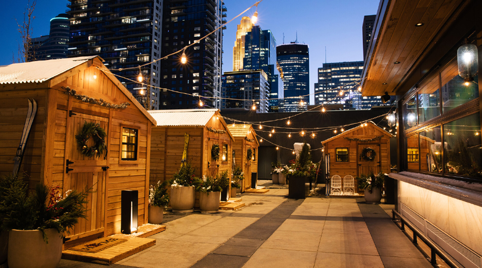 Four small cabins line an outdoor terrace in the middle of downtown