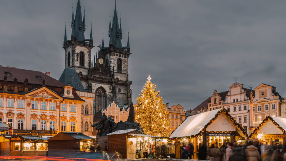 Christmas market stalls and a large lit-up Christmas tree in Old Town Square in Prague