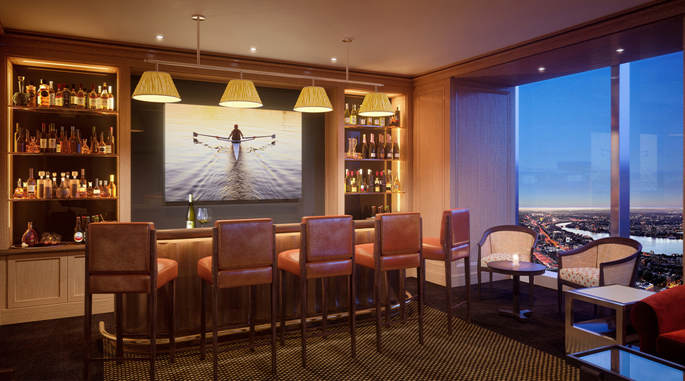 Private lounge area with bar counter, five upholstered bar stools, a small bistro table with two white chairs and a wall of floor-to-ceiling windows overlooking a city skyline at dusk